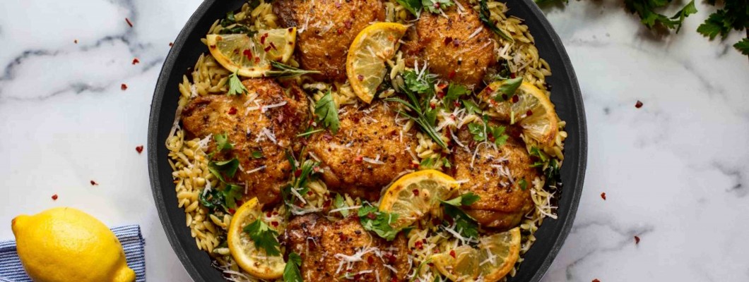 Chicken legs in a pan with Rizzoni pasta, lemon and spinach